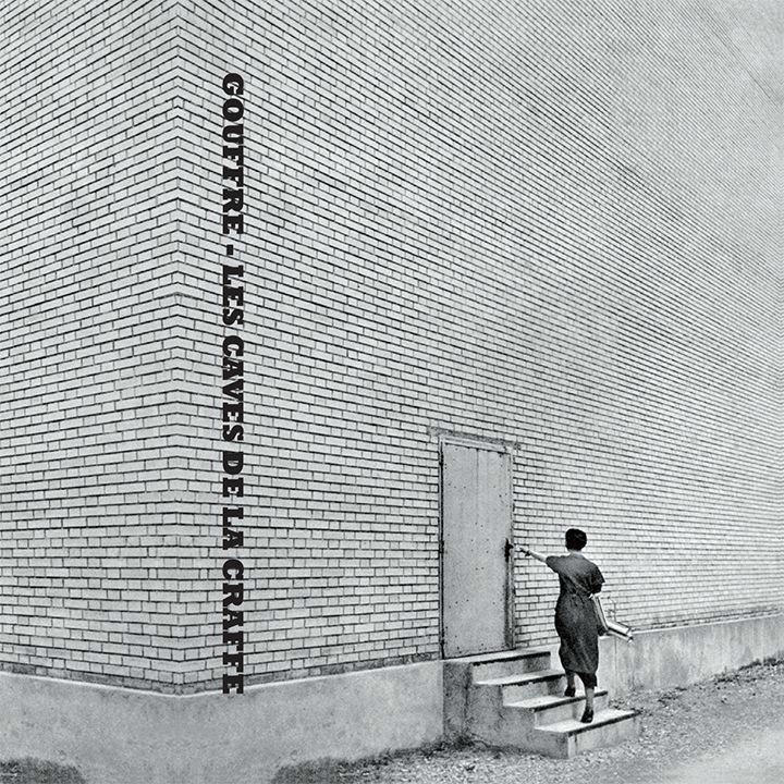 a b&w big wall and a girl opening a door